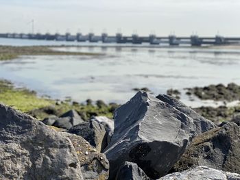 Close-up of rocks on beach against sky