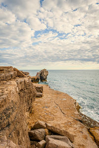 Scenic view of rocks in sea against sky.  pulpit rock on isle of portland in dorset coastline. uk