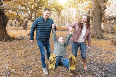 Full length of father and daughter in park during autumn