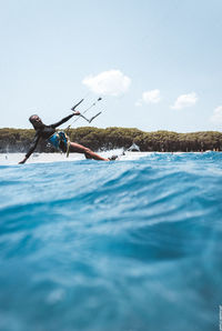 Portrait of woman kiteboarding on sea against sky