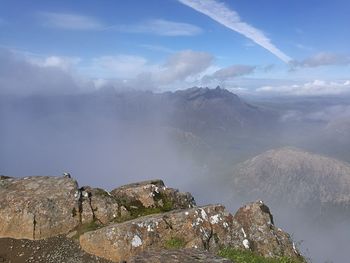 Scenic view of mountains against cloudy sky