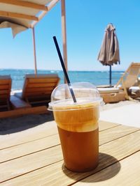 Drink on table against sea