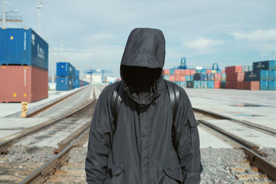 Man standing on railroad track against sky