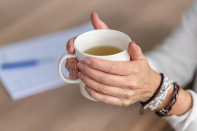 High angle view of woman holding tea cup