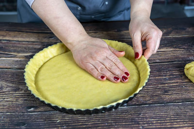 Women preparing delicious apple tart or pie .roll out the dough in a tart plate.