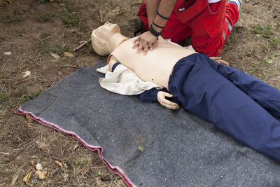 Midsection of paramedic performing cpr on mannequin