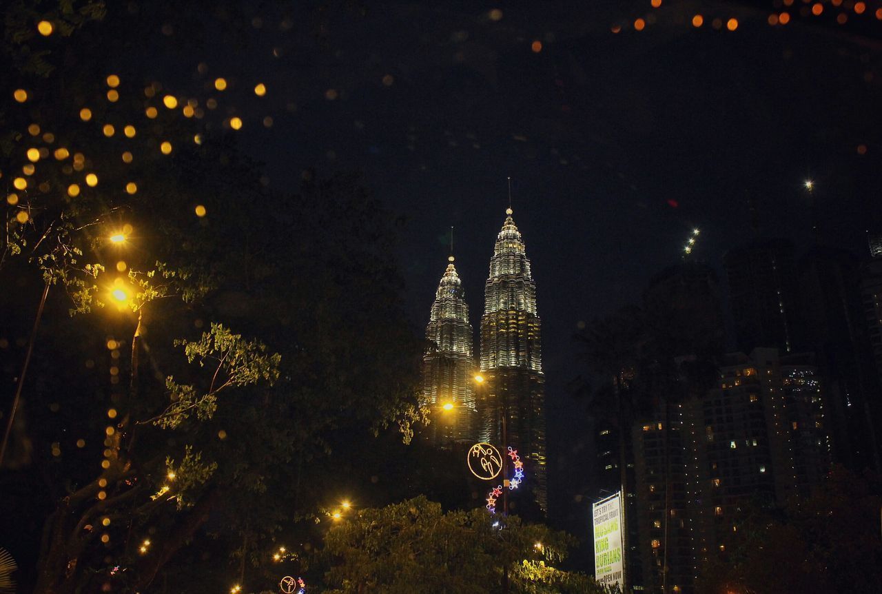 LOW ANGLE VIEW OF ILLUMINATED BUILDINGS AT NIGHT