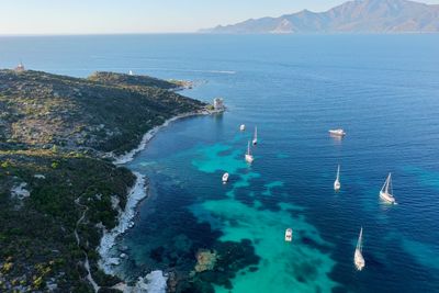High angle view of sea and mountains against sky