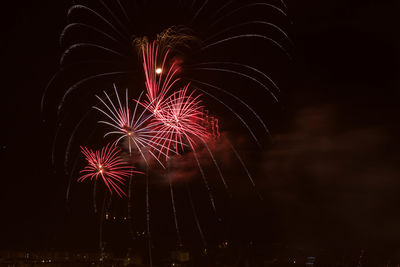 Low angle view of firework display at night