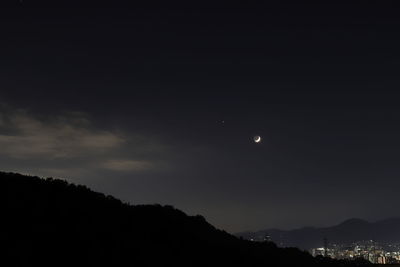 Low angle view of silhouette mountain against sky at night