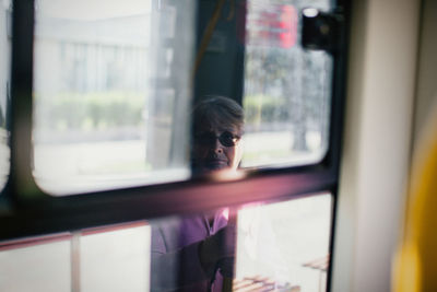 Portrait of man seen through train window