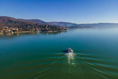 Aerial view of a sailing boat navigating on passignano sul trasimeno, a beautiful lake