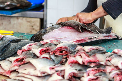 Midsection of man preparing fish for sale at market