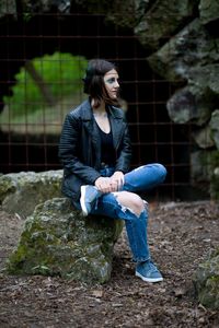 Side view of young woman sitting on field