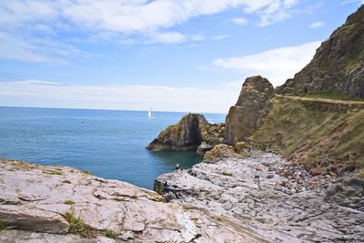 Rock formations by sea against sky