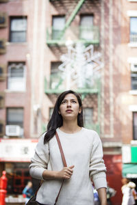 Thoughtful young woman walking in city