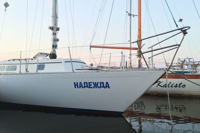 Sailboats moored in sea against sky