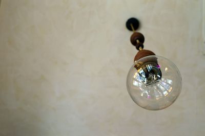 Low angle view of electric lamp hanging on ceiling