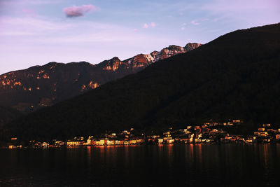 Scenic view of lake and mountains against sky at night
