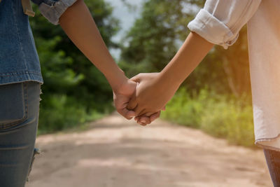 Midsection of couple holding hands