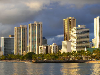 Modern buildings by city against sky