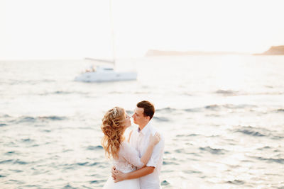 Side view of couple standing at sea shore