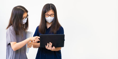 Young woman using smart phone against white background