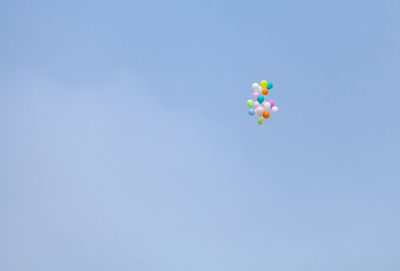 Low angle view of balloons against blue sky