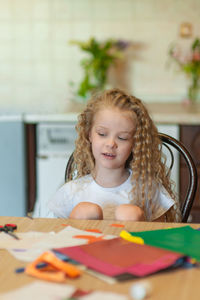 Girl sitting by table at home