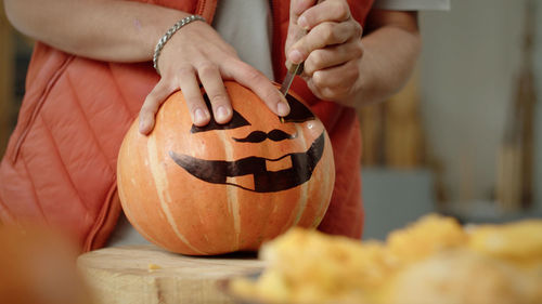 Midsection of woman holding pumpkin