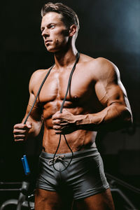 Shirtless man standing in darkroom