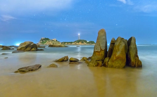 Rocks on sea shore against sky