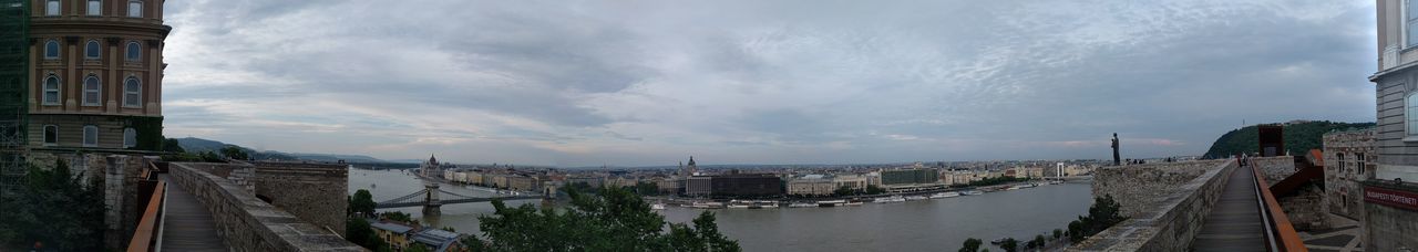 Panoramic view of city against cloudy sky