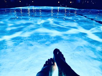Low section of person swimming in pool