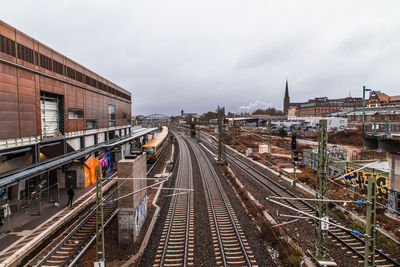 Railroad tracks amidst buildings in city against sky in berlin 