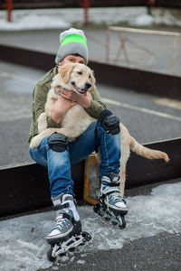 Boy wearing roller blades hugging dog