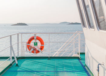 Life belt hanging on railing of ferry boat sailing in sea