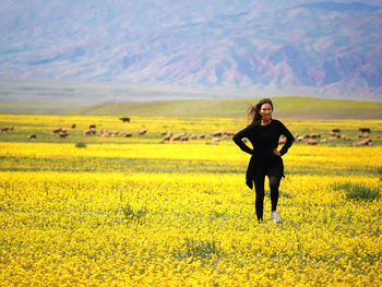 Full length of a smiling young man standing in field