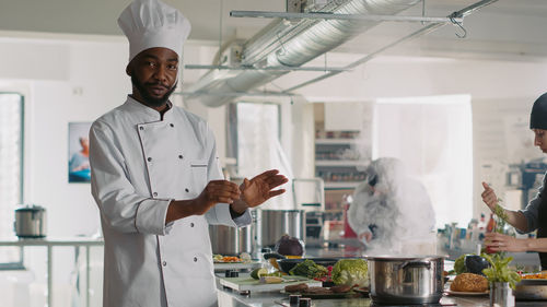 Male chef gesturing in kitchen