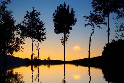 Silhouette trees against sky during sunset