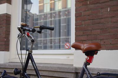 Close-up of bicycle parked on wall in city