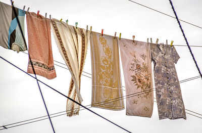 Low angle view of clothes hanging on rope against clear sky