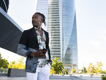 Low angle view of man standing against buildings in city