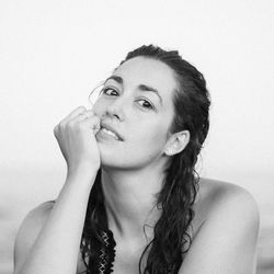 Close-up portrait of young woman against white background