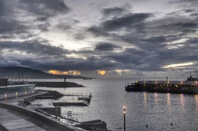 Boats in sea against sky during sunset