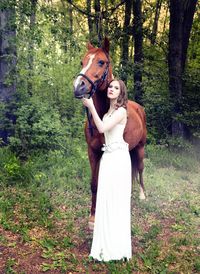 Portrait of young woman standing in forest