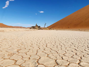 Scenic view of desert land against blue sky