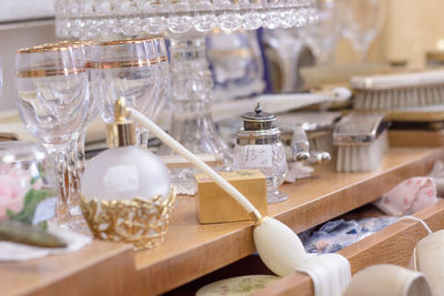 Close-up of perfume sprayer with drinking glasses