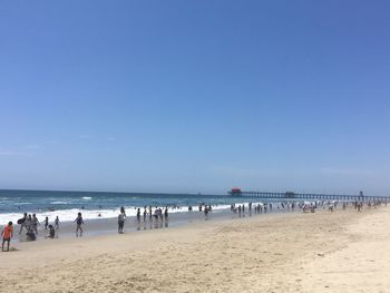 Crowd on beach against clear sky