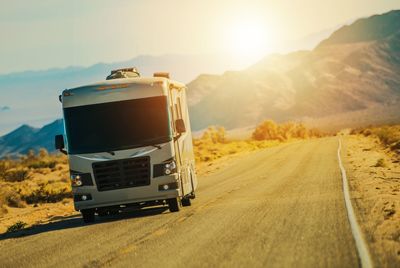 Semi-truck on road against sky during sunset